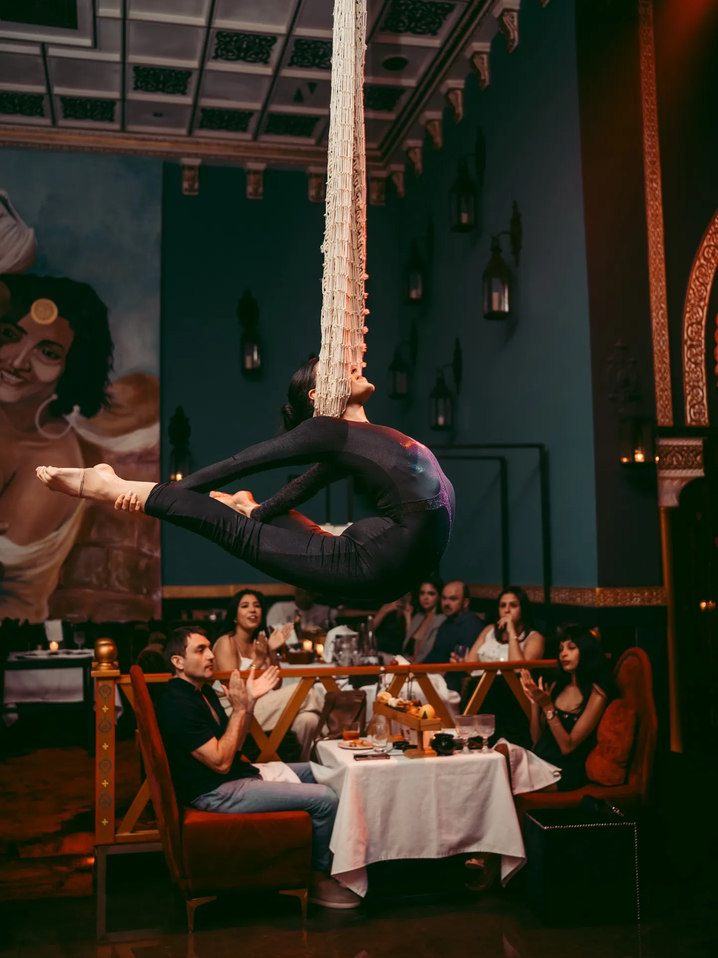 Aerial performer suspended above guests seated at dinner at LOV
