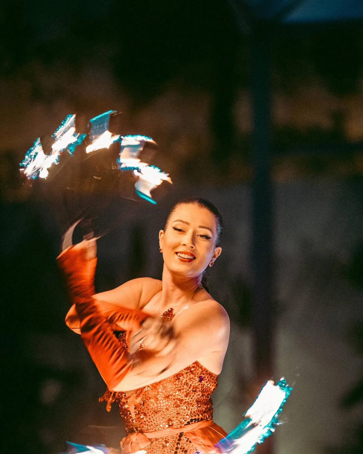 Saphira spinning lit fire fans during a performance at LOV Restaurant