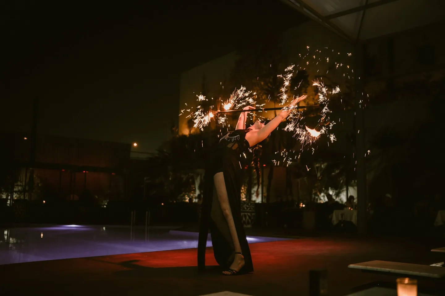 Performer with sparklers on the terrace after dark at LOV