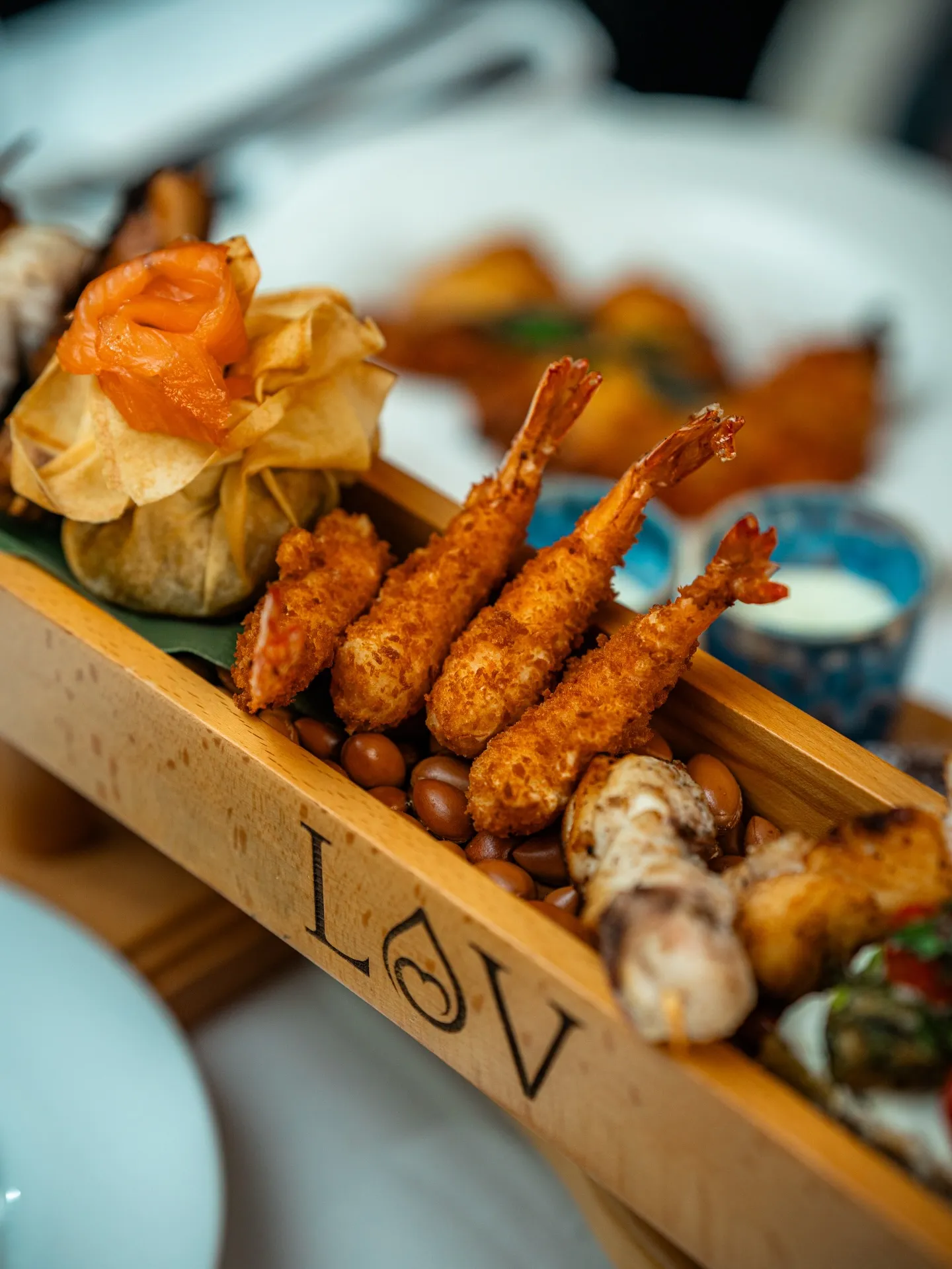 Fried starters and prawns served on a branded LOV wooden board