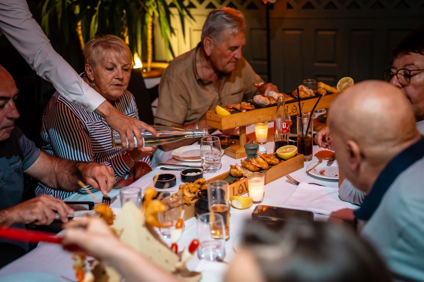 A long table mid-meal, dishes and glasses between guests at LOV